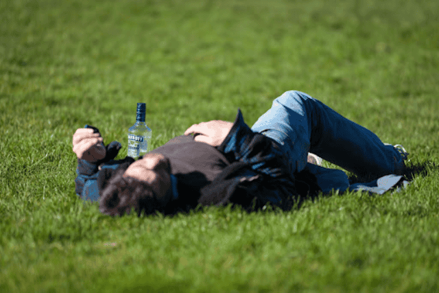 a drunk guy lying on the grass - featured image