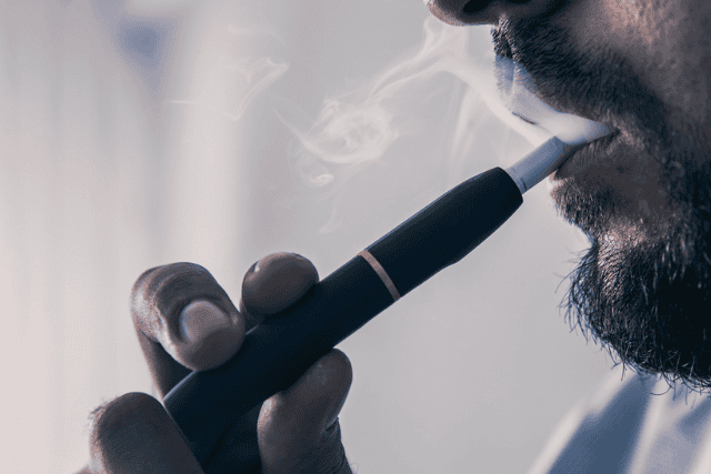a man smoking vape - featured image